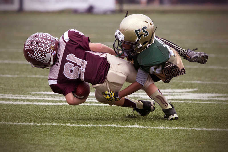 Young football palyers tackle action on the field