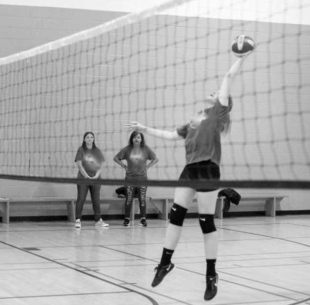 Girl leaps to strike volleyball